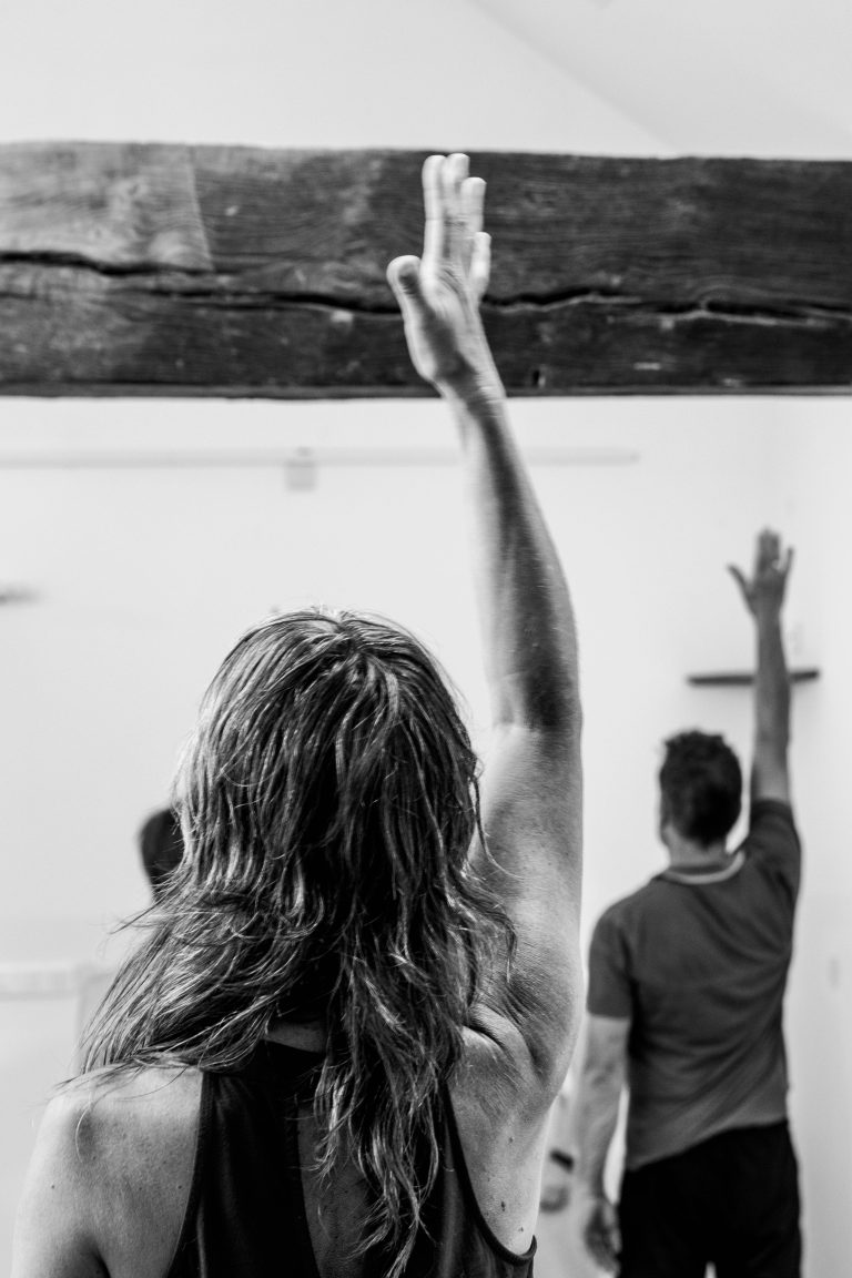 Personnes faisant du yoga avec Yoga Stella, une main vers le ciel