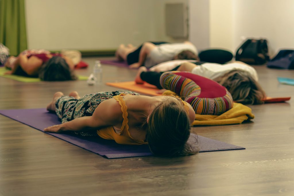 Plan sur les personnes au sol lors d'un cours collectif chez Yoga Stella